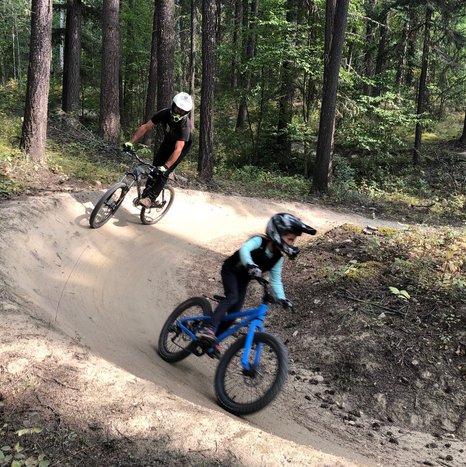 Dad and kid riding bikes downhill